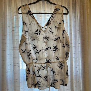 Sleeveless blouse with drawstring accent.  Creamy white with black accents.